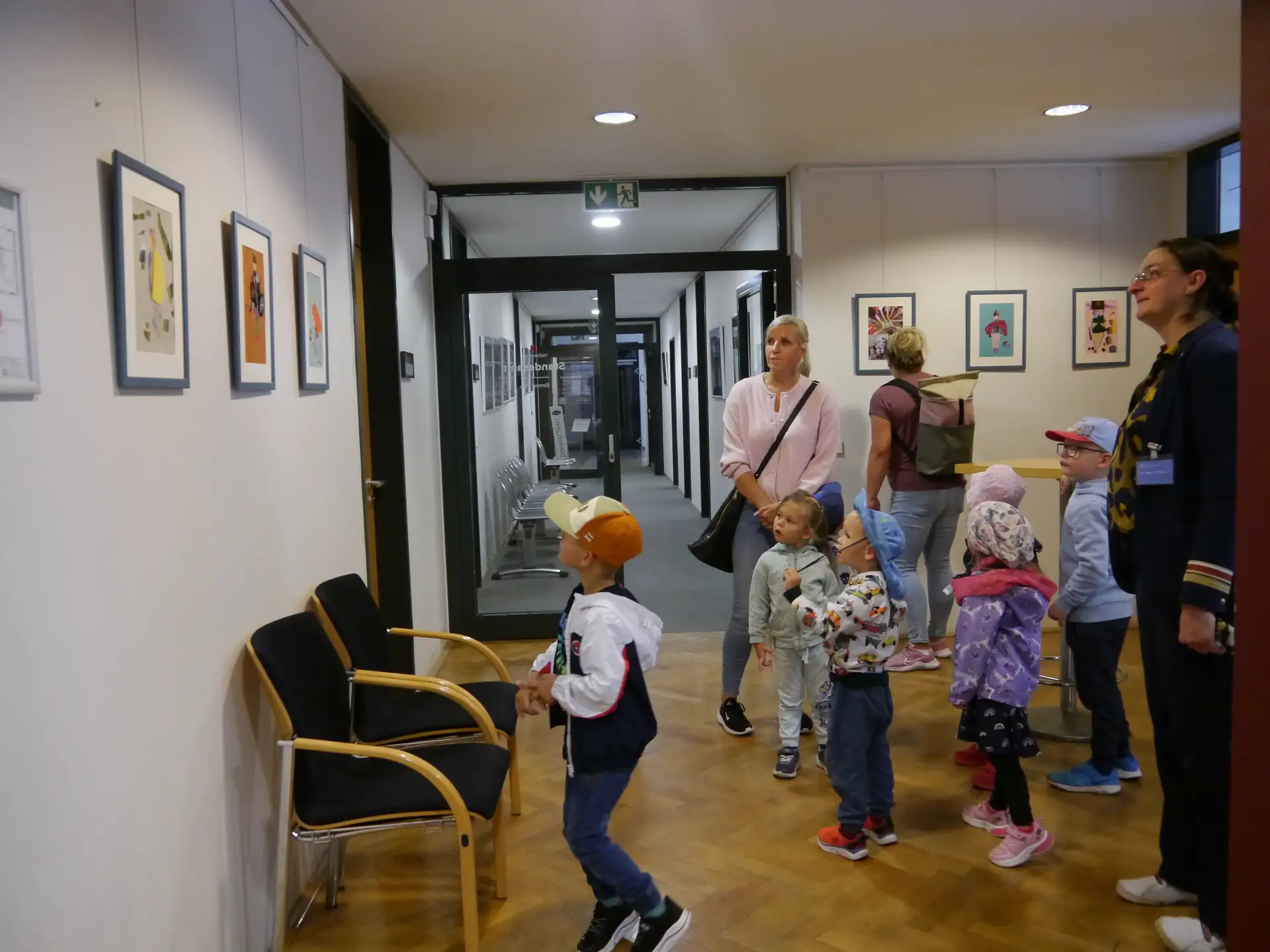 Mehrere Kinder sind vor einer Vitrine und Ausstellungsobjekten in einem Rathausraum zu sehen.